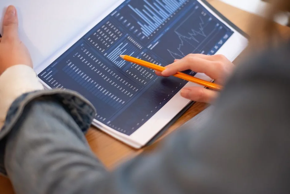 Hands reviewing marketing strategy alongside charts in an office setting.